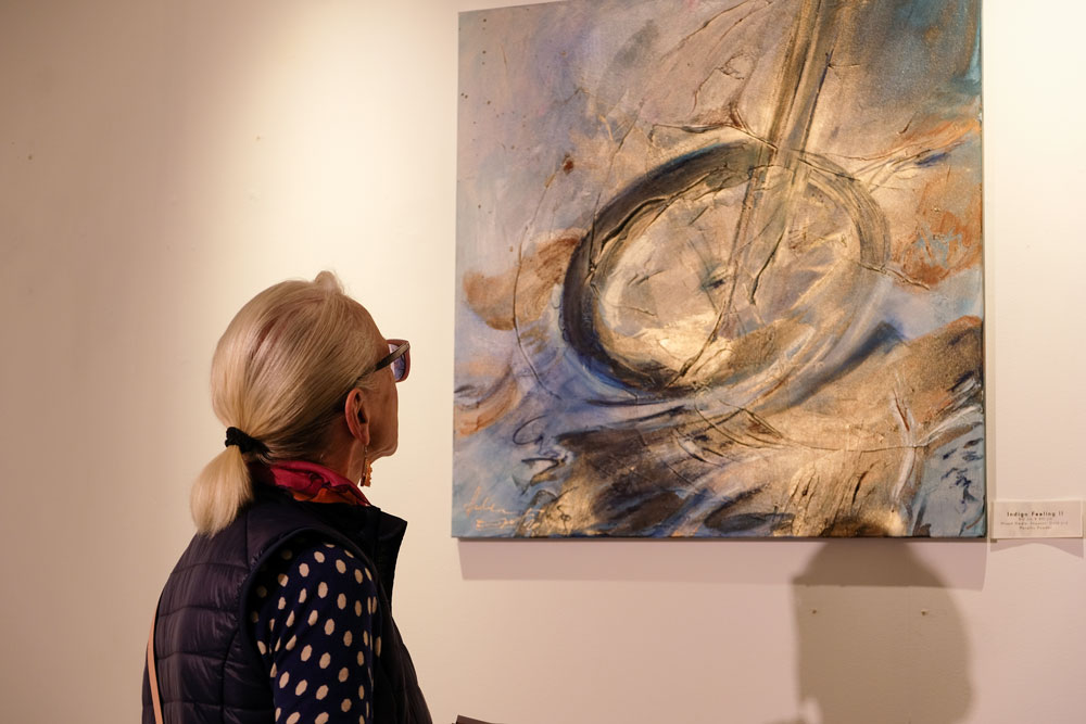 Picture depicting woman looking at Andrea Ehret artwork